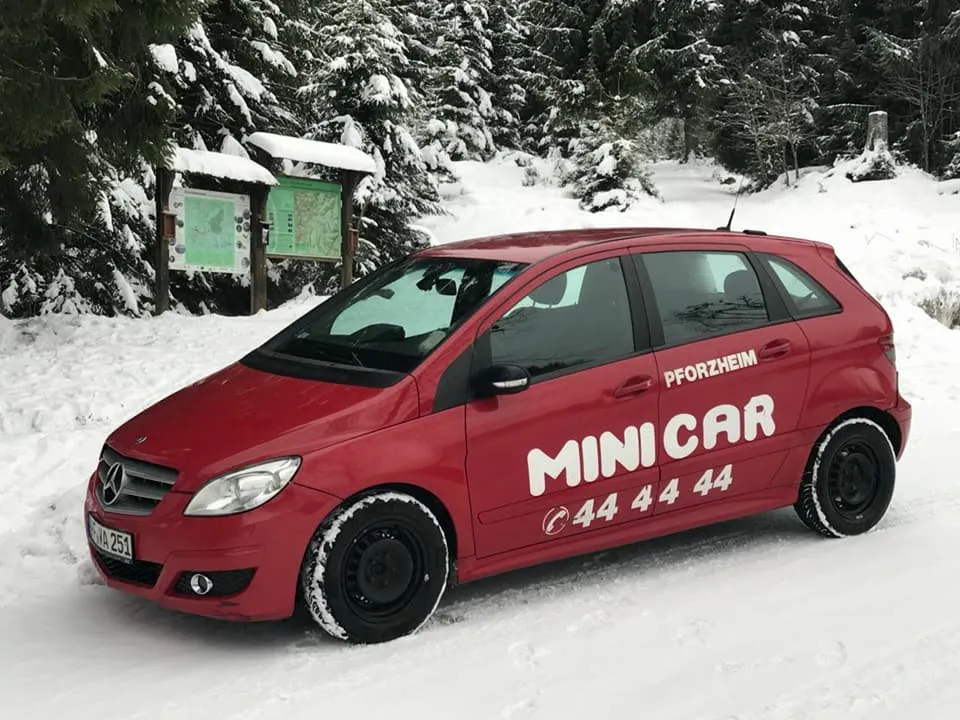 Rotes Minicar, eine Mercedes B-Klasse, im verschneiten Wald